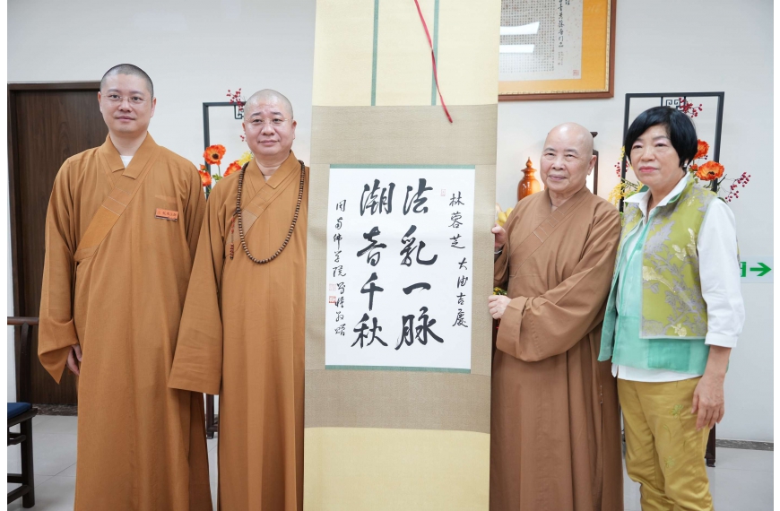 則悟和尚（左二）贈以書法「法乳一脈．潮音千秋」。